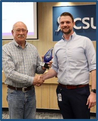 Outgoing Board Member receiving an award from the General Manager