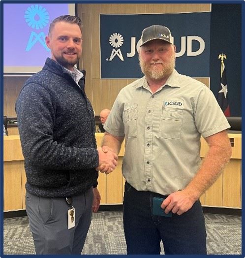 Staff member being presented with award from General Manager